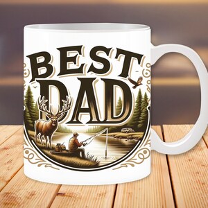 May include: White ceramic coffee mug with a brown and white illustration of a deer, a man fishing, and a van. The text "BEST DAD" is in a brown vintage font.