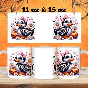 May include: Two white ceramic mugs with a Halloween-themed design. The design features a cartoon skeleton duck with pink bows, holding a pumpkin. The mugs are available in 11 oz and 15 oz sizes.