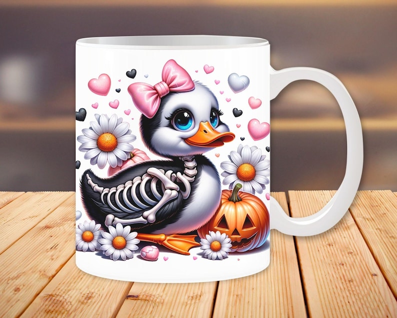 May include: White ceramic mug with a cartoon image of a duck with a pink bow, a skeleton, and a jack-o-lantern. The duck is surrounded by hearts and flowers.