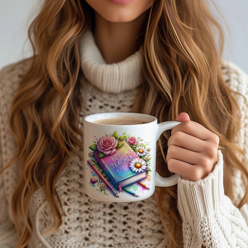 May include: White ceramic mug featuring a colourful illustration of a closed book with the words "Best Teacher" on the cover, surrounded by flowers and pencils.