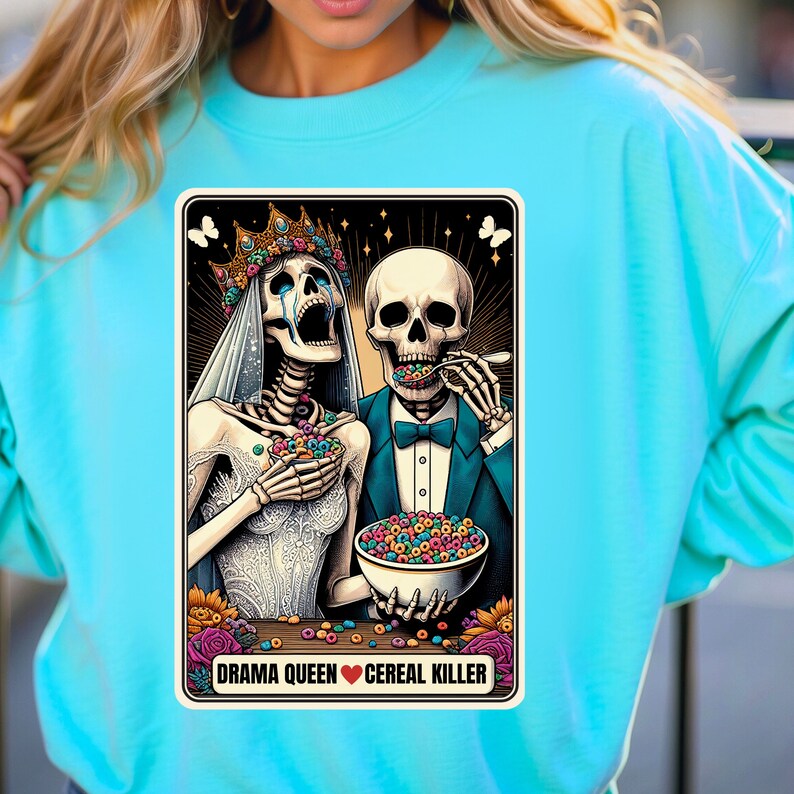 May include: A colorful illustration of a skeleton couple dressed in wedding attire. The bride is crying and the groom is eating cereal. The text below the image reads "Drama Queen &hearts; Cereal Killer".