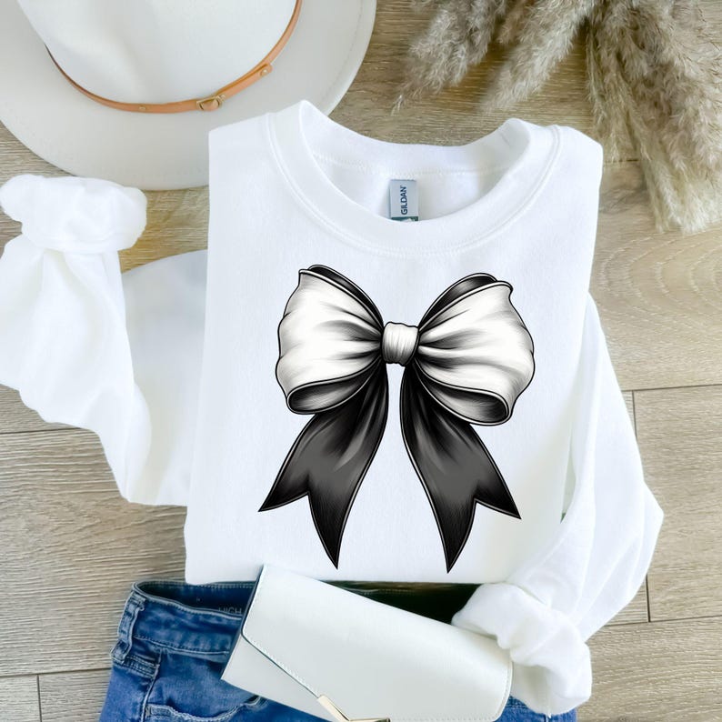 Puede incluir: Sudadera blanca con un gr&aacute;fico de lazo blanco y negro.