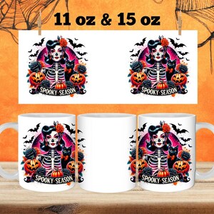 May include: Two white ceramic mugs with a black and white illustration of a woman with a skull face and a black cat. The illustration is surrounded by bats, roses, and pumpkins. The text "Spooky Season" is printed on the mugs.