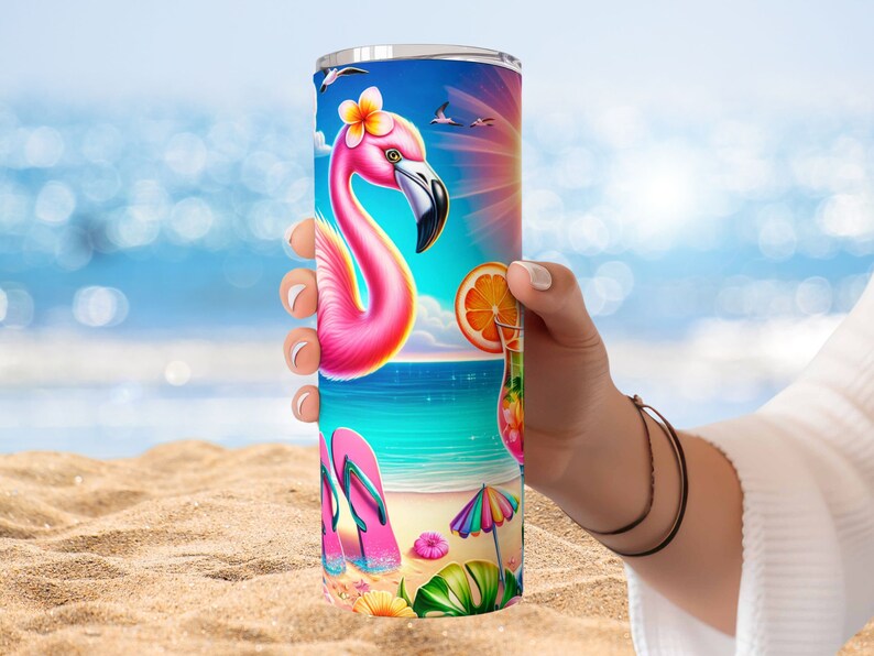 May include: A pink flamingo with a flower in its hair stands on a beach with a blue sky and ocean in the background. The tumbler has a colorful design with flip flops, a beach umbrella, and a tropical drink.