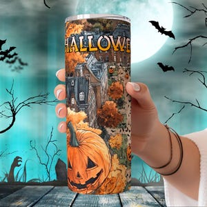 May include: A stainless steel tumbler with a Halloween themed design. The design features a spooky cityscape with a pumpkin, bats, and the word "HALLOWEEN".
