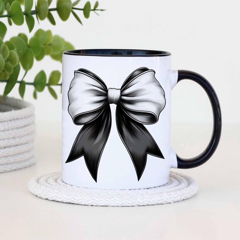 Puede incluir: Taza de cer&aacute;mica blanca con borde y asa negros. La taza presenta un dise&ntilde;o de lazo negro y blanco.