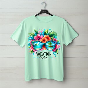 May include: A light green t-shirt with a colorful graphic of sunglasses with tropical flowers and palm trees. The sunglasses reflect a beach scene. The text "VACATION Mode" is printed below the sunglasses.