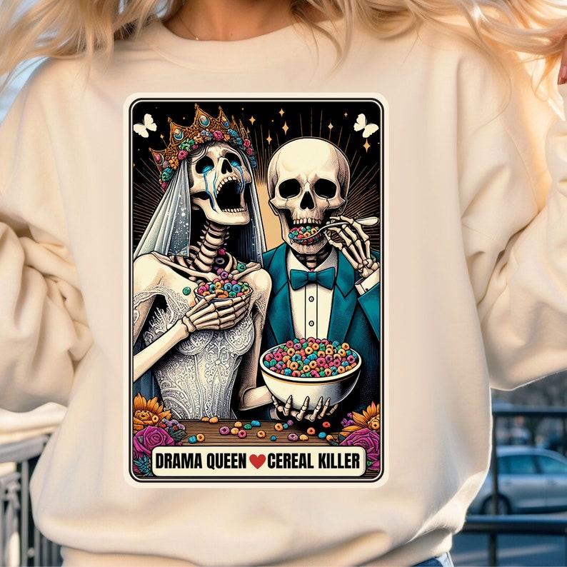 May include: A colorful illustration of two skeletons dressed as a bride and groom. The bride is wearing a white dress and a crown, and the groom is wearing a tuxedo. They are both eating cereal from a bowl. The text below the image reads "Drama Queen &hearts; Cereal Killer".
