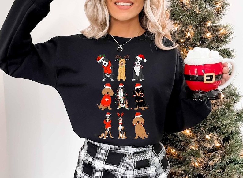 May include: Black sweatshirt featuring a festive design of various dog breeds wearing Santa hats and holiday attire. The dogs are arranged in rows, adding a touch of holiday cheer. The sweatshirt is a comfortable, casual style.