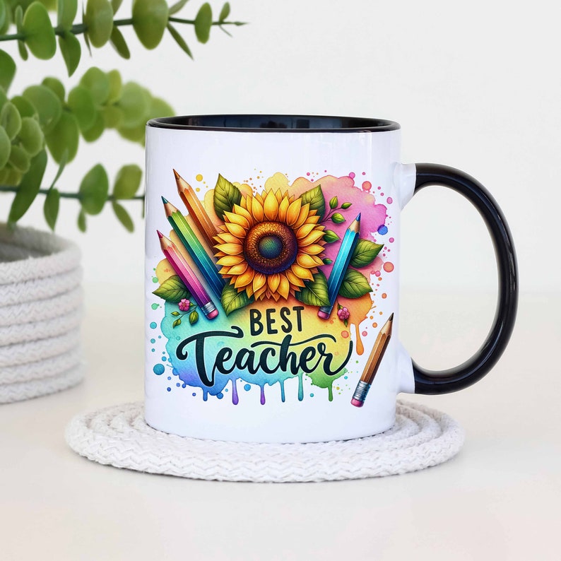 May include: White ceramic mug with a black rim and handle. The mug features a colourful illustration of a sunflower and pencils with the text "Best Teacher" in black.
