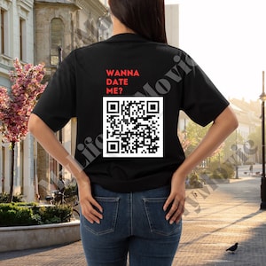Puede incluir: Camiseta negra con el texto "Wanna Date Me?" en rojo y un código QR en blanco y negro.