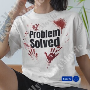 Peut inclure: T-shirt blanc avec des éclaboussures de sang rouge et le texte "Problème résolu".