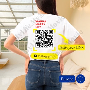 Może przedstawiać: Biała koszulka z czerwonym napisem "WANNA MARRY ME?". Widoczny jest również kod QR i napis "Insert your LINK". Koszulka ma przycisk Instagram i logo Europy.