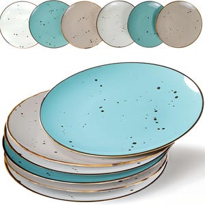 May include: A stack of ceramic plates in various colors, including white, teal, and beige. Each plate has a speckled design and a gold rim. The plates are oval-shaped and suitable for serving food.