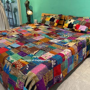 Puede incluir: Una colcha de retazos colorida hecha de saris reciclados, con una variedad de colores y patrones vibrantes. La colcha está extendida sobre una cama con dos fundas de almohada a juego. La colcha es una pieza de arte única y hecha a mano.