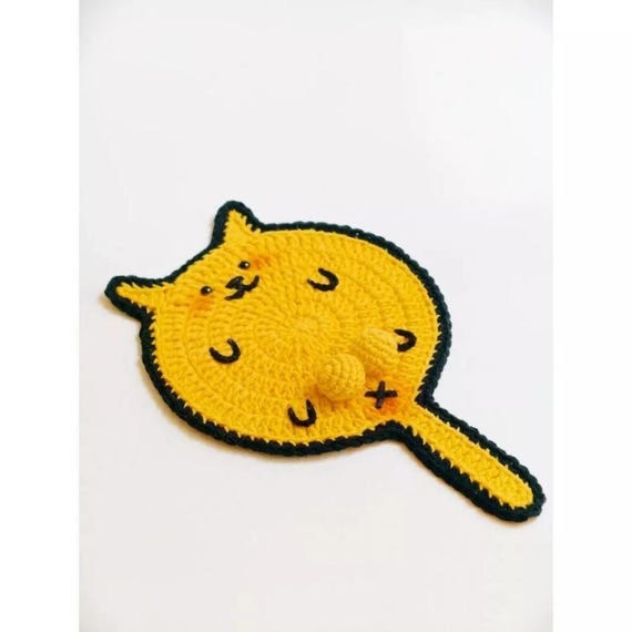A chonky crochet cat clutching a tiny 3D ball as your coaster — absurdly cute, genuinely handmade, and does an actual job on your desk.