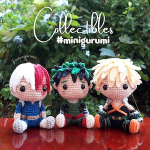 May include: Three crocheted anime characters, each with a different hairstyle and outfit. The characters are sitting on a wooden surface. The text "Collectibles #minigurumi" is visible above the characters.