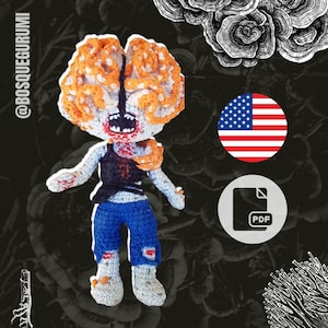 May include: A crocheted amigurumi toy of a zombie with orange and white brain-like hair, wearing a black vest and blue jeans. The toy is holding its arms out and has a wide, toothy grin. The image also includes a US flag and a PDF icon.