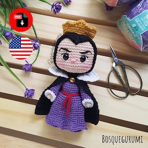 May include: A handmade crochet doll of a character with a gold crown, black cape, and purple dress. The doll has a stern expression and is made with various yarn colors. The doll is a handmade amigurumi.