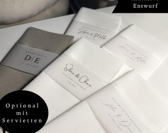 Puede incluir: Una colección de servilletas de tela rectangulares blancas y beige envueltas en bandas de papel translúcido. Cada banda presenta nombres, fechas y frases impresas como Selma & Chan, Julia & Daniel y D/E. Las superposiciones de texto incluyen "inklusive Entwurf" y "Optional mit Servietten."