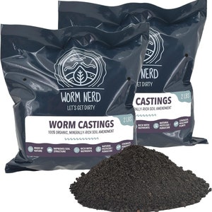 May include: Two 2-pound bags of Worm Nerd Worm Castings, a 100% organic, minerally-rich soil amendment. The bags are black with white text and a logo of a worm with a leaf. The text on the bags reads "Worm Nerd Let's Get Dirty" and "Worm Castings 100% Organic, Minerally-Rich Soil Amendment". The bags are sitting on a pile of the worm castings, which are a dark brown color.