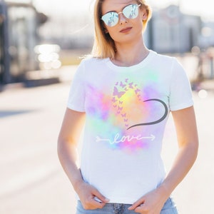 May include: White t-shirt with a tie-dye effect and a design of butterflies forming a heart with the word "love" written below.