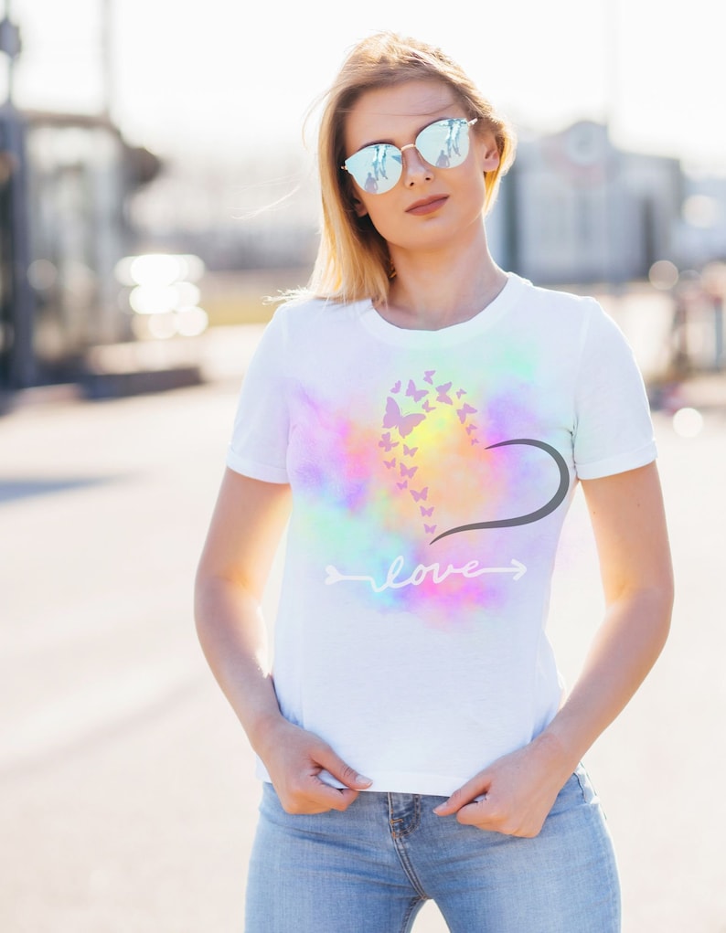 May include: White t-shirt with a tie-dye effect and a design of butterflies forming a heart with the word "love" written below.