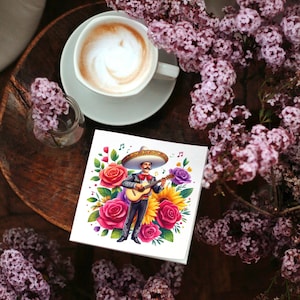 May include: A colorful illustration of a man playing a guitar with a sombrero and flowers surrounding him. The illustration is printed on a white card.