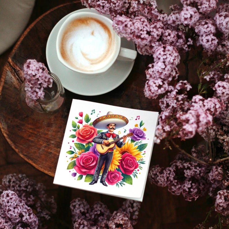 May include: A colorful illustration of a man playing a guitar with a sombrero and flowers surrounding him. The illustration is printed on a white card.