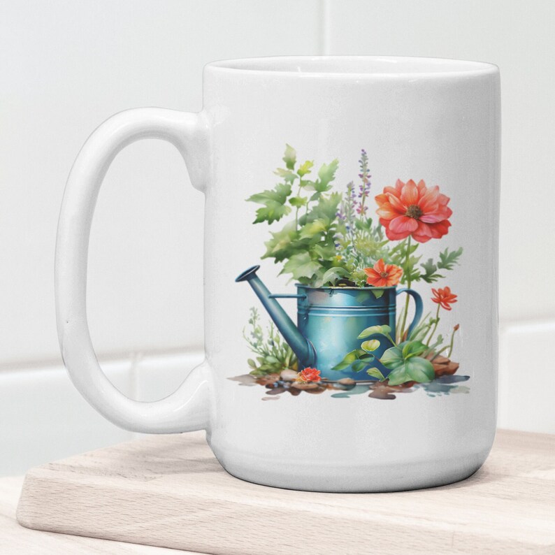 Puede incluir: Taza de cer&aacute;mica blanca con una regadera azul llena de flores y vegetaci&oacute;n. Las flores son rojas, rosas y moradas. La regadera tiene un pico y un asa. La taza est&aacute; sobre una superficie de madera.
