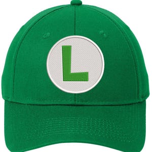 May include: A green baseball cap with a white circle and a green letter L in the center.
