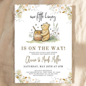 Puede incluir: Invitación a un baby shower con una ilustración de Winnie the Pooh y el texto "Our Little Honey Is On The Way!". La invitación incluye detalles para el baby shower de Anna & Mark Miller, como la fecha, la hora y el lugar.