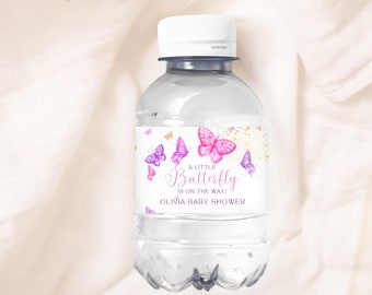 May include: A water bottle label with a pink and purple butterfly design. The label says "A Little Butterfly is on the way! Olivia Baby Shower".