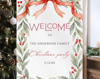 May include: A white welcome sign on an easel with a watercolor design. The sign features a red bow, greenery, and the words "WELCOME TO THE ANDERSON FAMILY Christmas party" in red. The date is 11.12.XX.