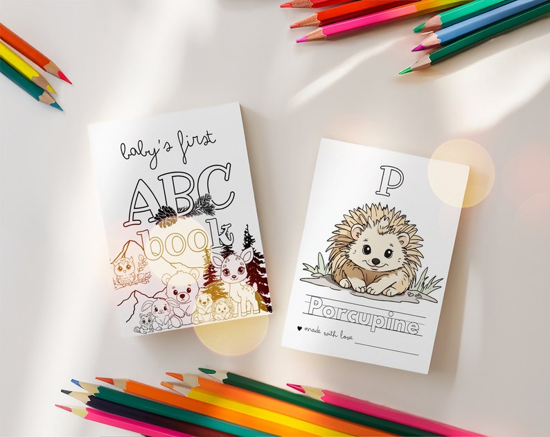 May include: A black and white coloring book for babies with the title "baby's first ABC book". The cover features a mountain scene with animals like an owl, deer, and bears. The book is open to a page with a black and white illustration of a porcupine and the letter "P" with the word "Porcupine" written below.