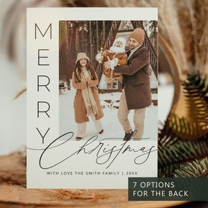 May include: A rectangular holiday greeting card featuring a vertical photograph of a family in a snowy outdoor setting. The card displays the text MERRY in a vertical sans-serif font, the script text Christmas, and the text WITH LOVE THE SMITH FAMILY | 20XX.