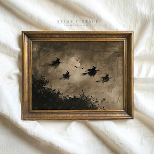May include: A framed painting in a dark gold wooden frame featuring a sepia-toned scene of four silhouettes of witches flying on broomsticks across a cloudy night sky with a full moon and small bats. The text ATLAS VINTAGE Curated Vintage Art is visible.