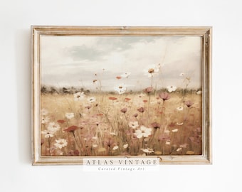 May include: A framed vintage painting depicting a field of wildflowers in shades of white, pink, and red. The painting has a soft, dreamy feel and is set against a backdrop of a blue sky with fluffy clouds. The frame is a light wood colour.