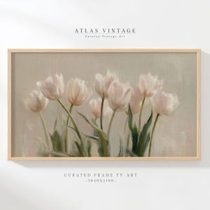 Puede incluir: Impresión enmarcada de una pintura floral con tulipanes rosas y blancos. La obra de arte tiene una estética vintage, con un fondo beige claro y un marco de madera natural. El texto "ATLAS VINTAGE" y "CURATED FRAME TV ART" son visibles.