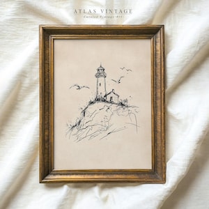May include: Framed vintage art print featuring a lighthouse on a rocky cliff, with seagulls in flight. The artwork is a black and white sketch, set against a neutral background, and framed in a gold-toned wooden frame. The text "ATLAS VINTAGE Curated Vintage Art" is at the top.