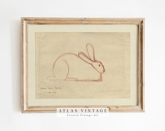 May include: A framed vintage drawing of a rabbit in brown pencil on a beige background. The drawing is signed "Zoo des Petits" and dated "Summer 1939".