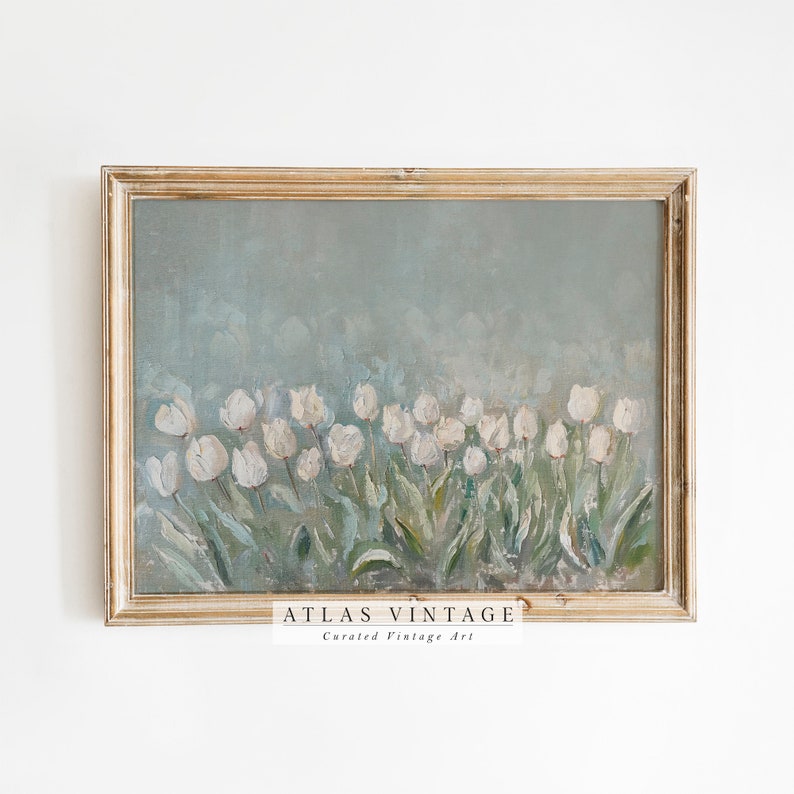 May include: A vintage framed painting of white tulips on a pale blue backdrop. The artwork is in a distressed gold frame. The text "ATLAS VINTAGE Curated Vintage Art" is at the bottom.