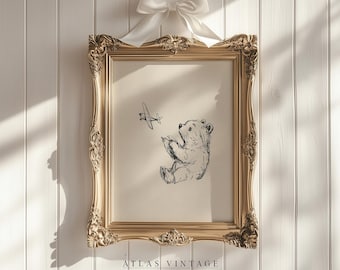 May include: A gold framed print with a black and white illustration of a bear looking up at a small airplane flying overhead. The print is titled "Atlas Vintage" and has the text "Curated Vintage Art" below the title.