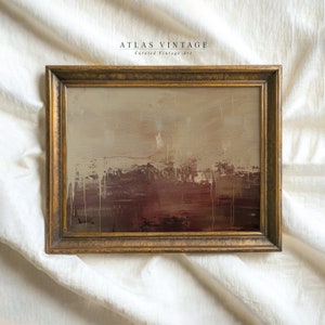 May include: A framed abstract painting with a brown, beige, and gold color scheme. The painting is in a gold frame and is on a white background.