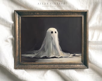 Puede incluir: Una pintura enmarcada de un fantasma blanco con dos ojos negros sobre un fondo oscuro. El marco es de madera marrón oscuro con un borde dorado.
