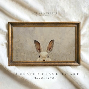 May include: A framed print of a white rabbit peeking out from behind a textured, light brown background. The frame is gold with a simple design. The text "CURATED FRAME TV ART <3840x2160>" is below the frame.