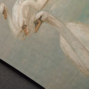 May include: A painting of three white swans with their heads turned towards the viewer. The swans are painted in a realistic style with soft, feathery details. The background is a light blue, suggesting a sky or water.