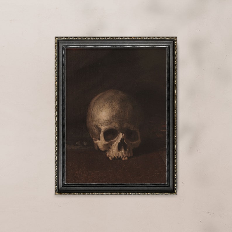 May include: A framed painting of a human skull in a dark brown frame. The skull is white and has a detailed depiction of the bone structure.