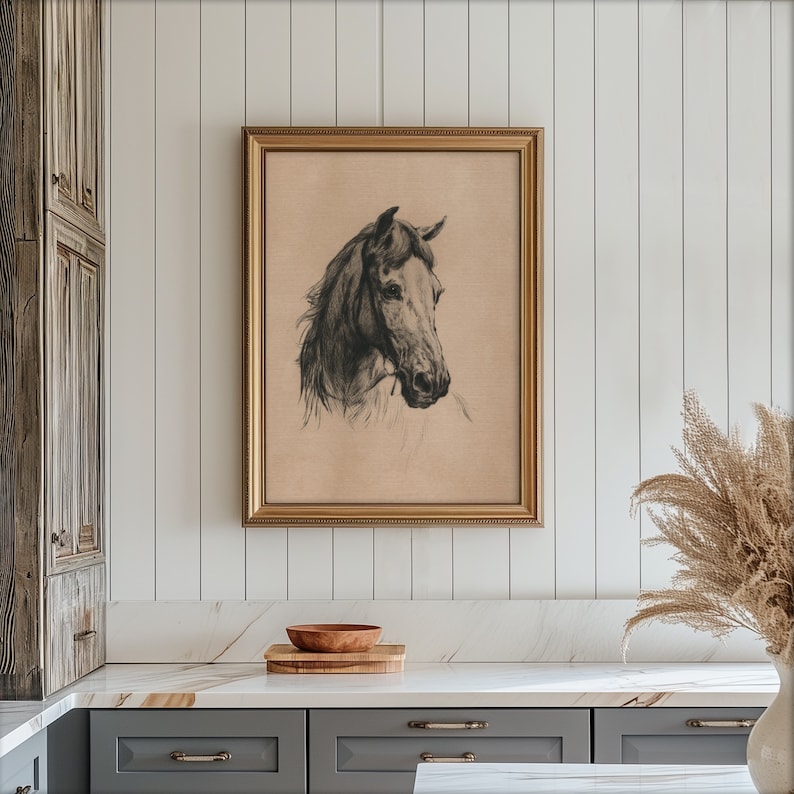 May include: A black and white drawing of a horse's head in a gold frame. The drawing is on a beige background.