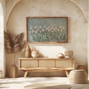 May include: A light wood cabinet with woven panels and a painting of white tulips in a wooden frame. Decorative vases and a woven lamp sit on the cabinet. A woven rug and a decorative pouf are on the floor.